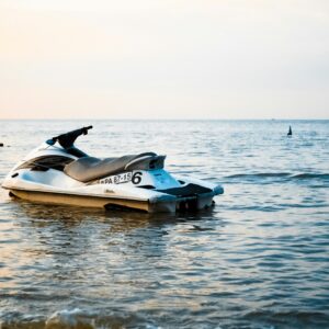 A lone jet ski rests on calm ocean waters during a serene sunset. Perfect for travel and leisure themes.